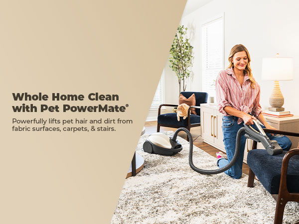 Woman vacuuming with a Pet PowerMate in a cozy living room.