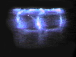 Wint-O-Green Lifesaver being crushed with a pair of pliers in a dark room
