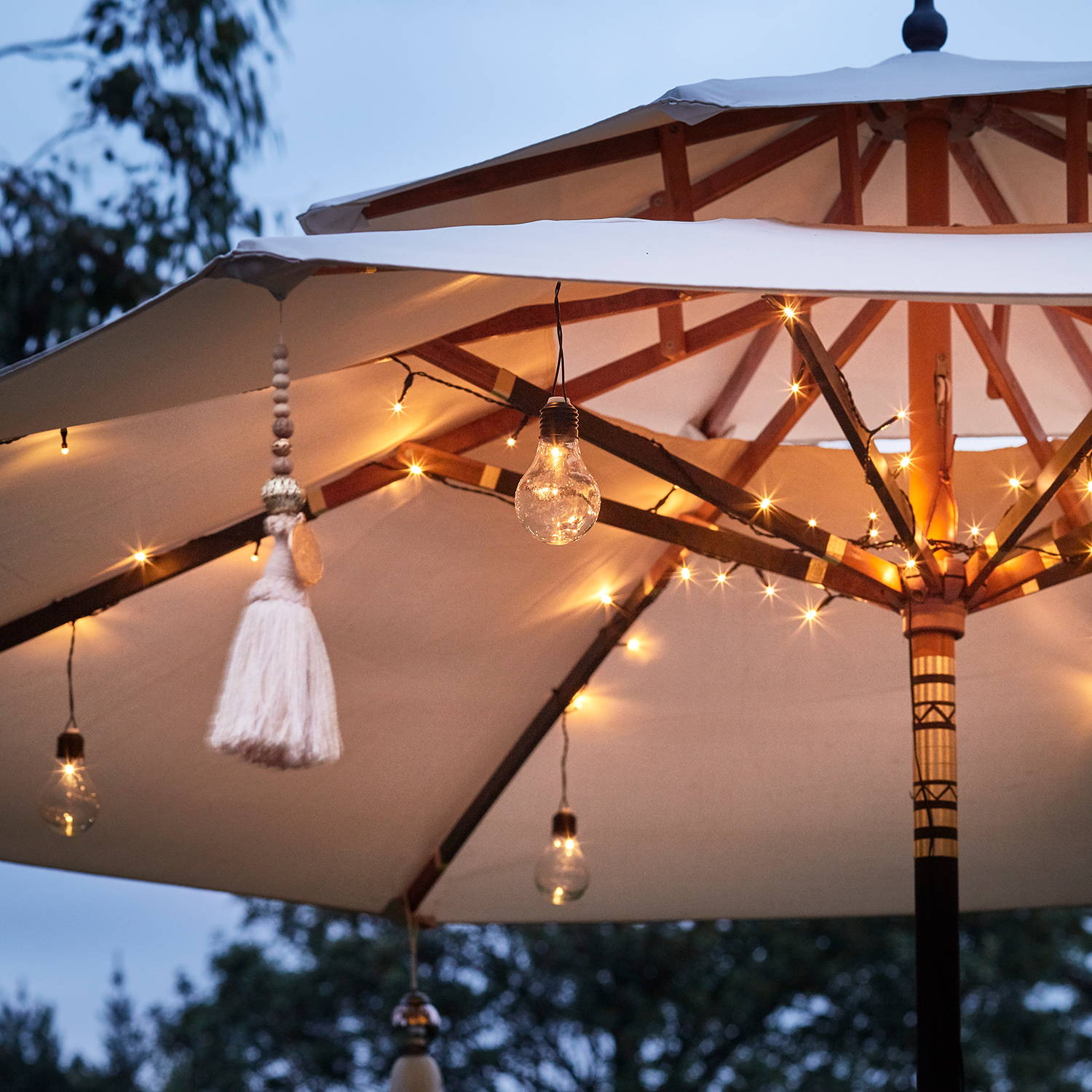 Warm white string lights with festoons in a parasol at night.
