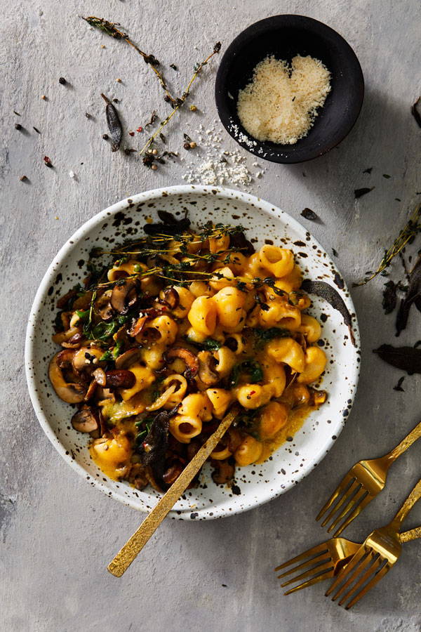 Shellbows pasta in a creamy butternut squash sauce with mushrooms, fennel and swiss chard served in a bowl