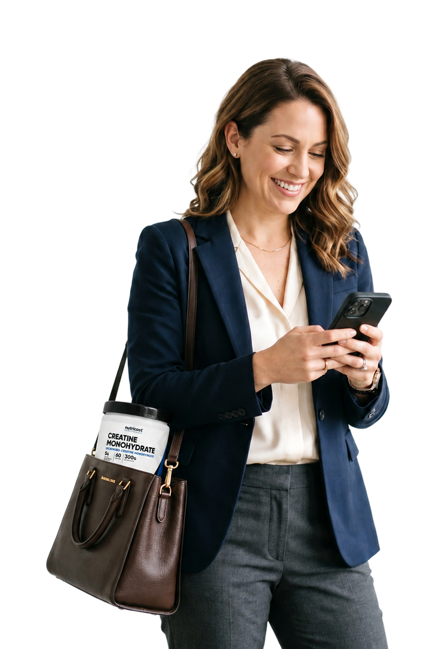 Woman in a blazer texting on her phone, carrying a brown handbag.