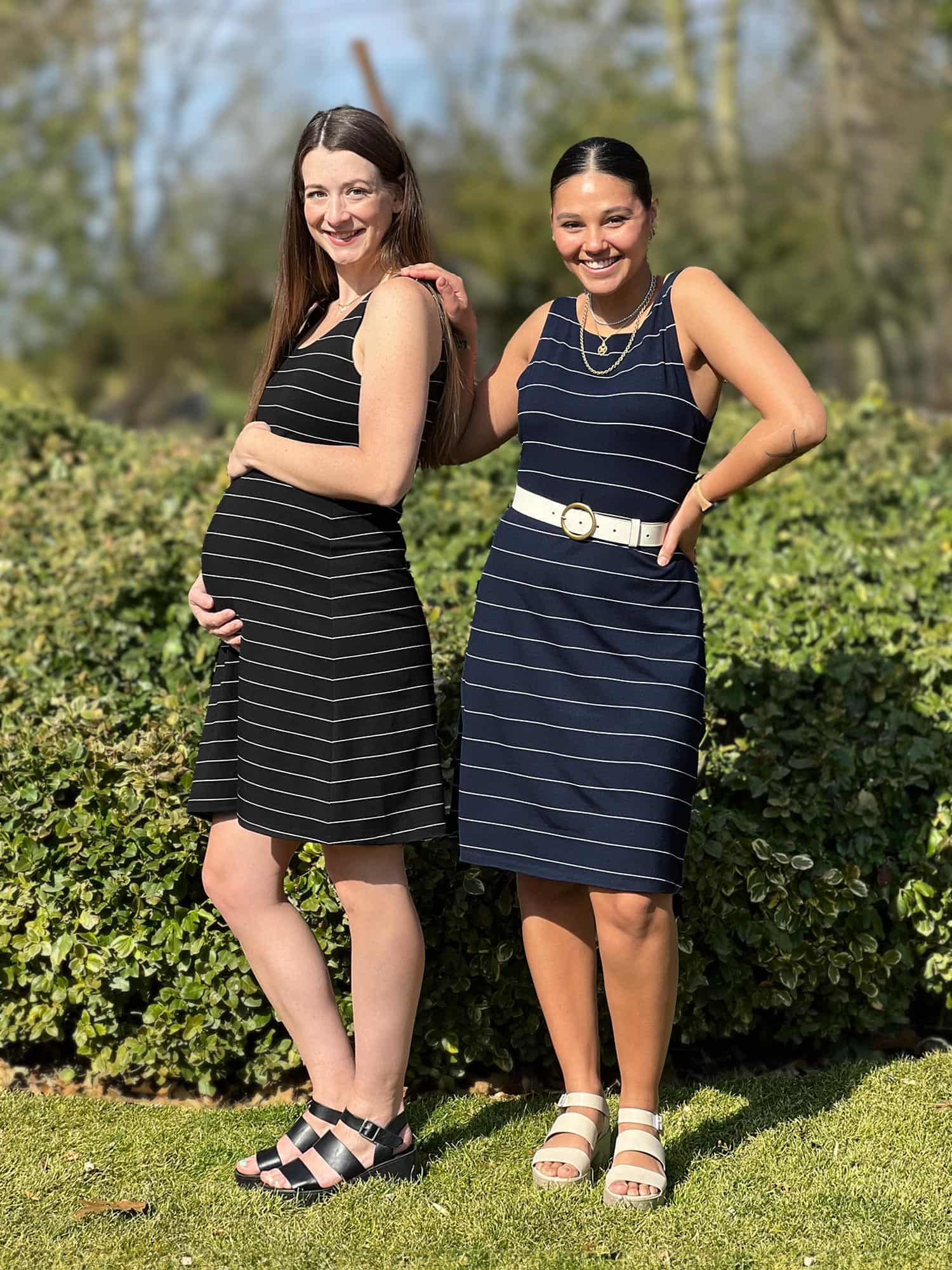 Two women (one pregnant) standing next to each other wearing Miik's Jaaron reversible tank dress in stripe in the same size