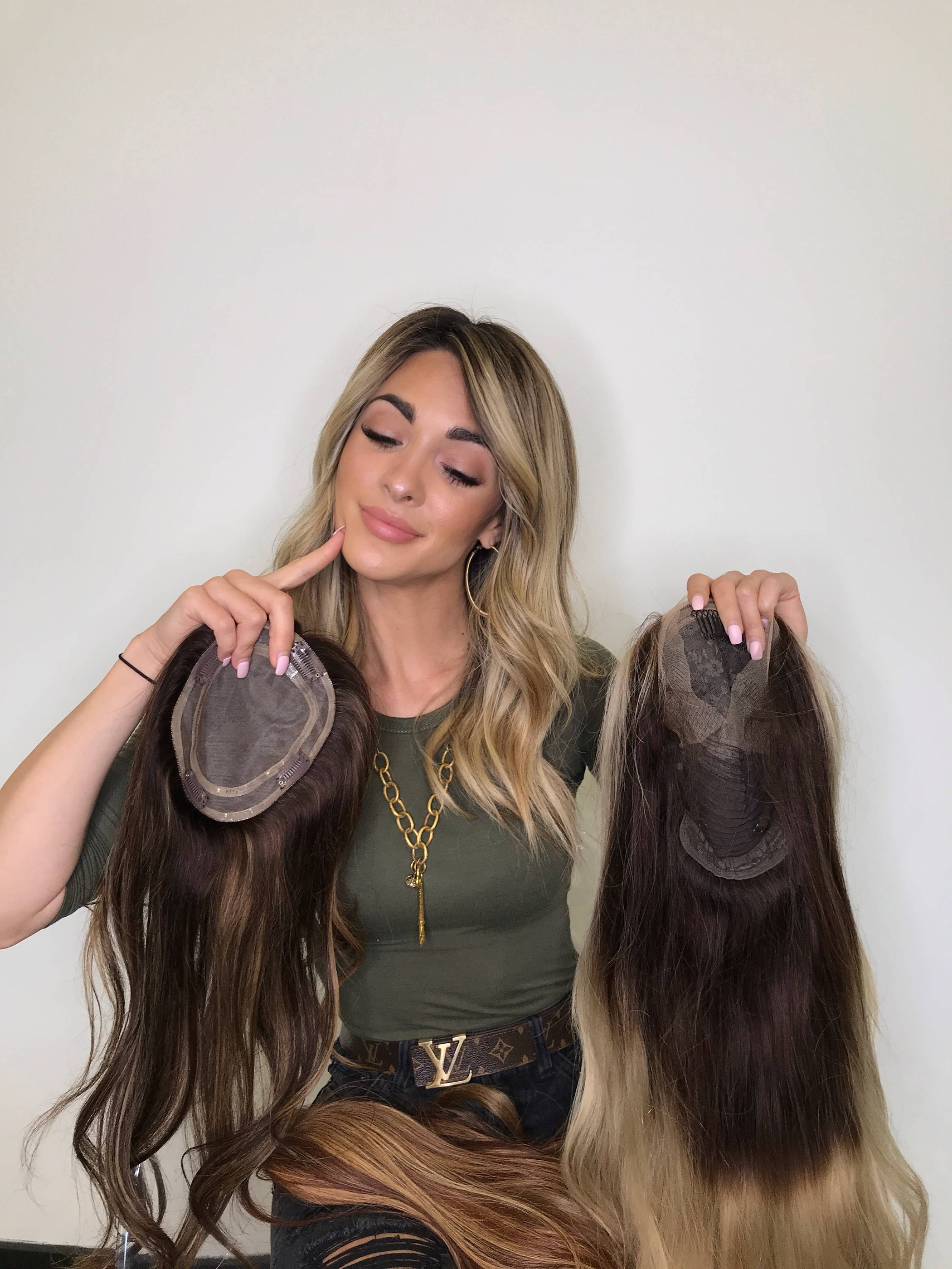 Woman holding up two different wigs