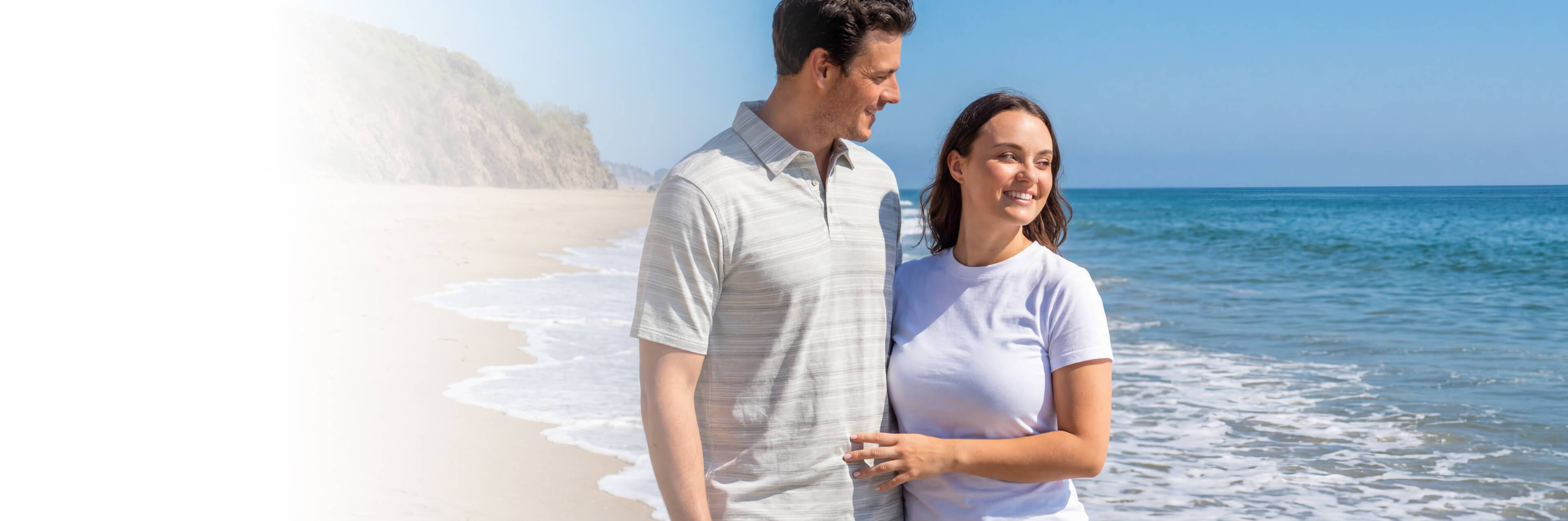 a woman and man standing on a beach wearing cariloha bamboo clothing