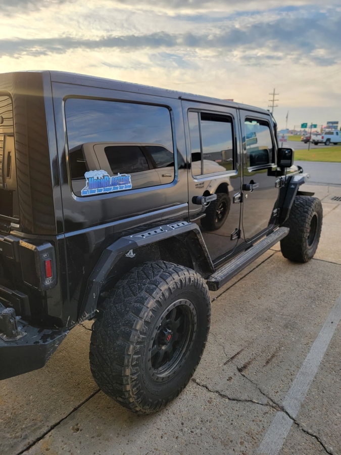 Front-three-quarter Chance's 2014 Jeep Wrangler Unlimited Rubicon exterior seven-slot grille round headlights bumper Conductor's Special 544K Nightmare Edition train horn kit featured customer install photo 1