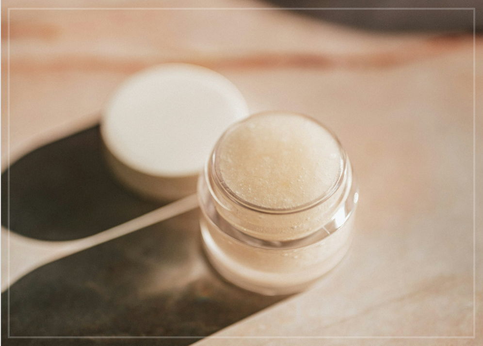 A small pot of makeup, with the lid removed and sat behind it.
