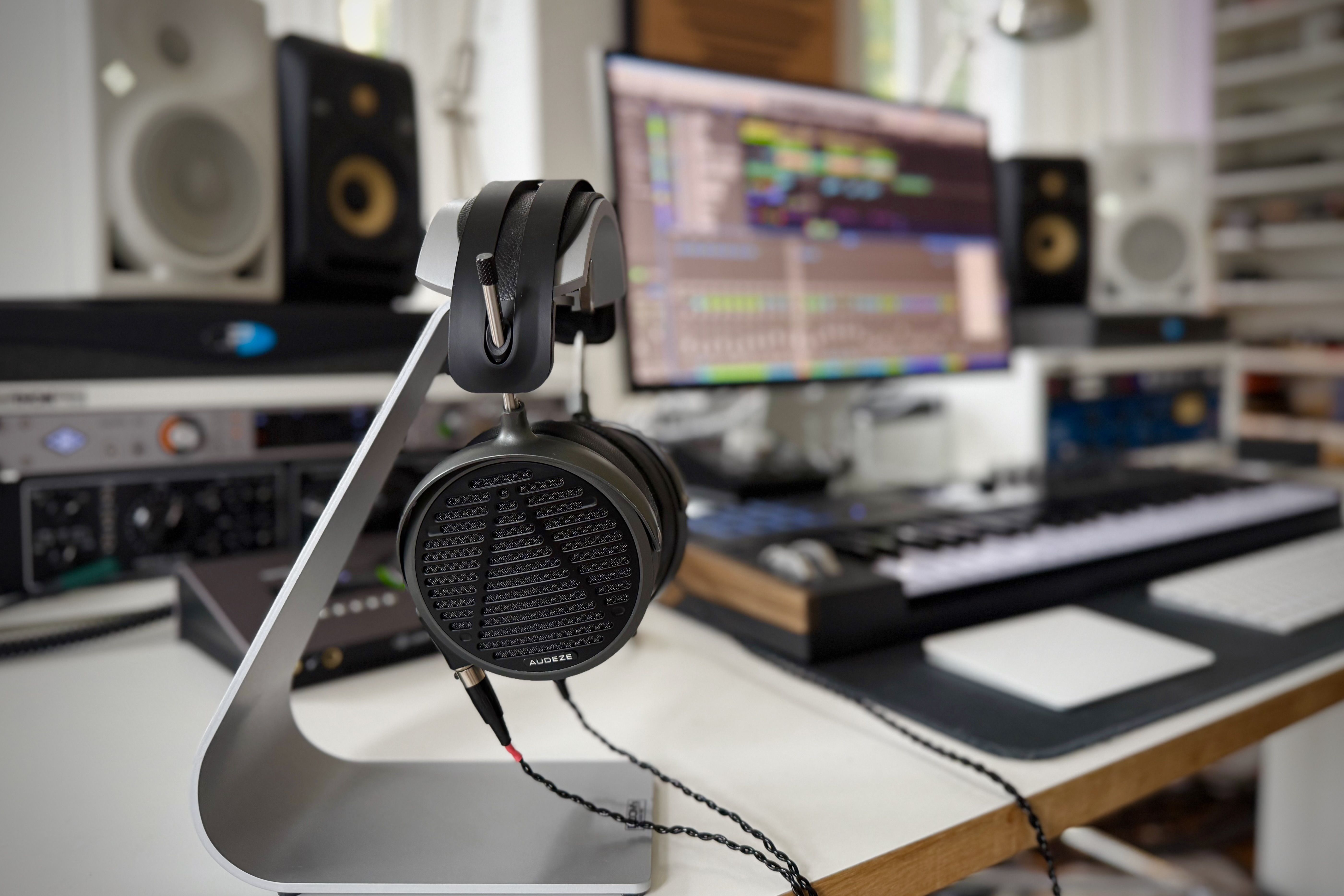 Audeze MM-500 headphones on a headphone stand In the studio in front of speakers and monitors 