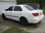Rear three-quarter white Toyota Corolla driveway garage door Nathan AirChime K5LA train horn gallery photo 2