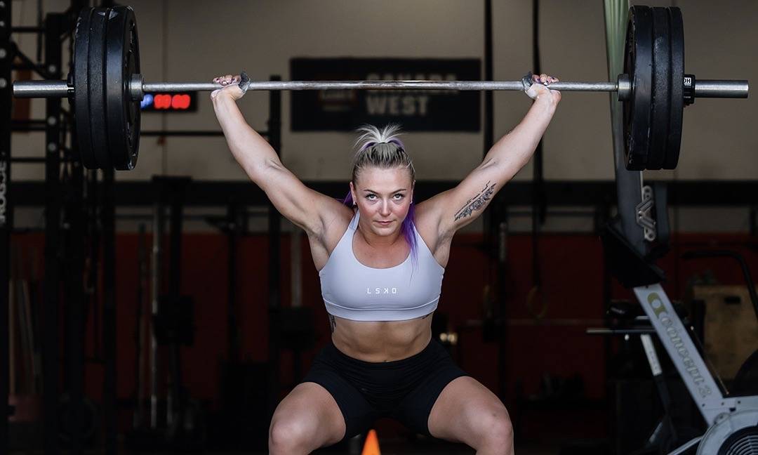 girl lifting a barbell above her head