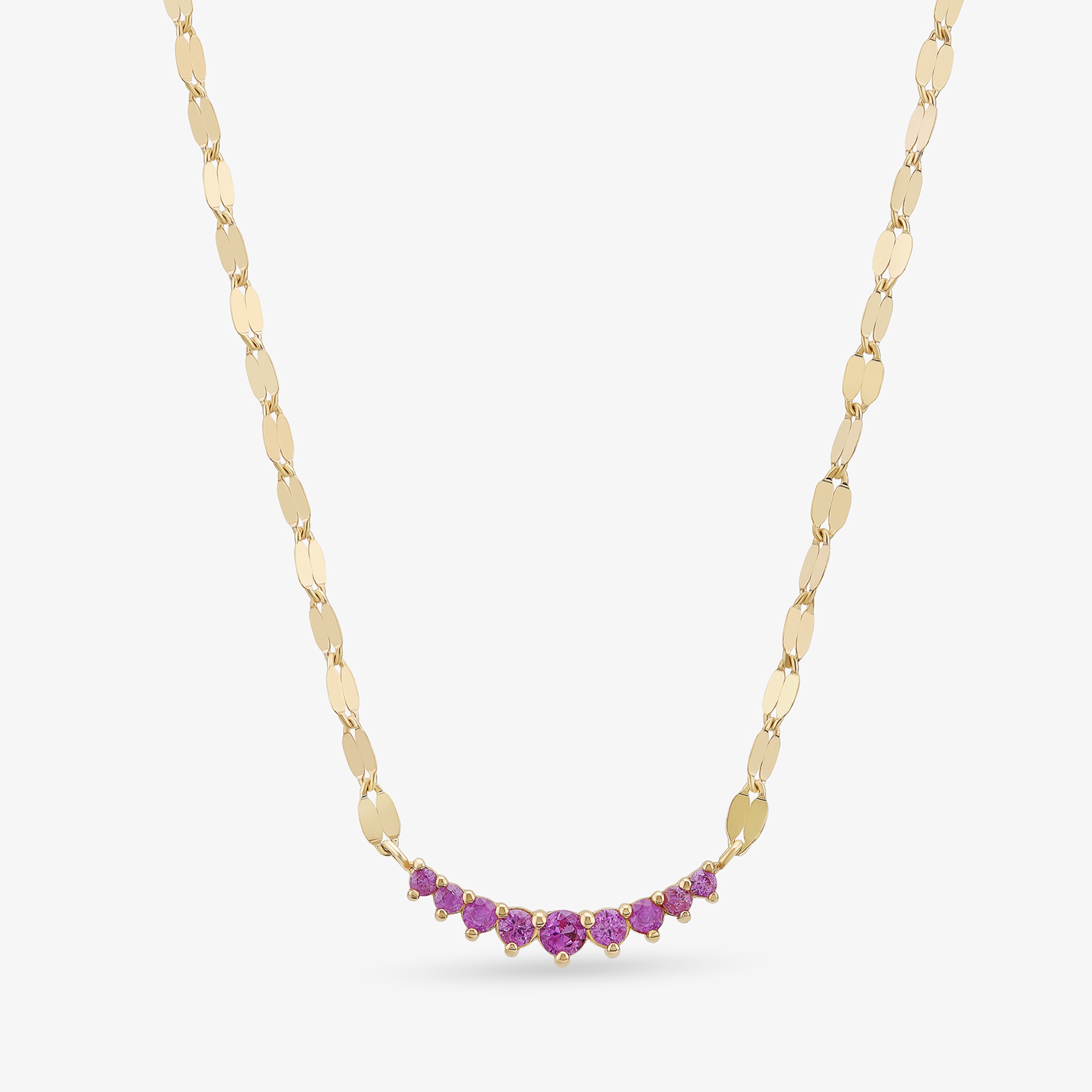 Gold necklace with pink gemstones arranged in a curved design.