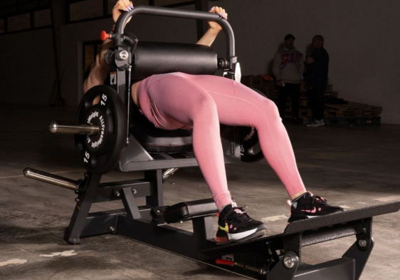 Person using a leg press machine in a gym setting.