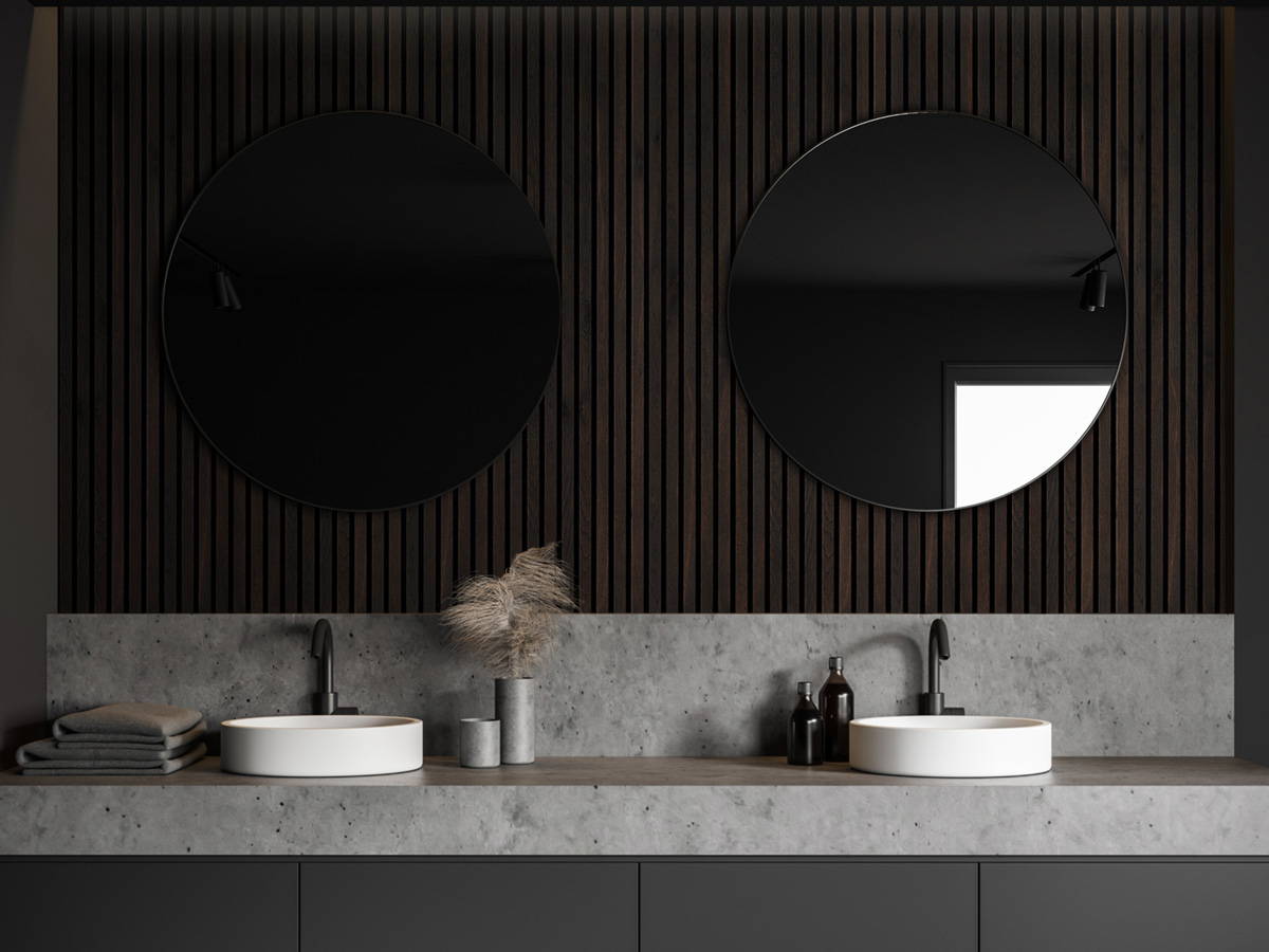 Dark wood paneling applied in bathroom with mirrors mounted infront.
