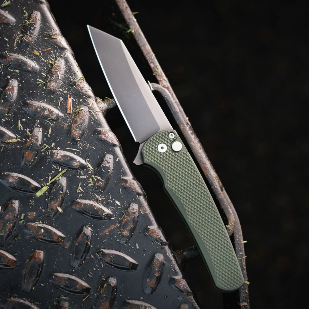 A folding knife with a green handle on a textured surface.