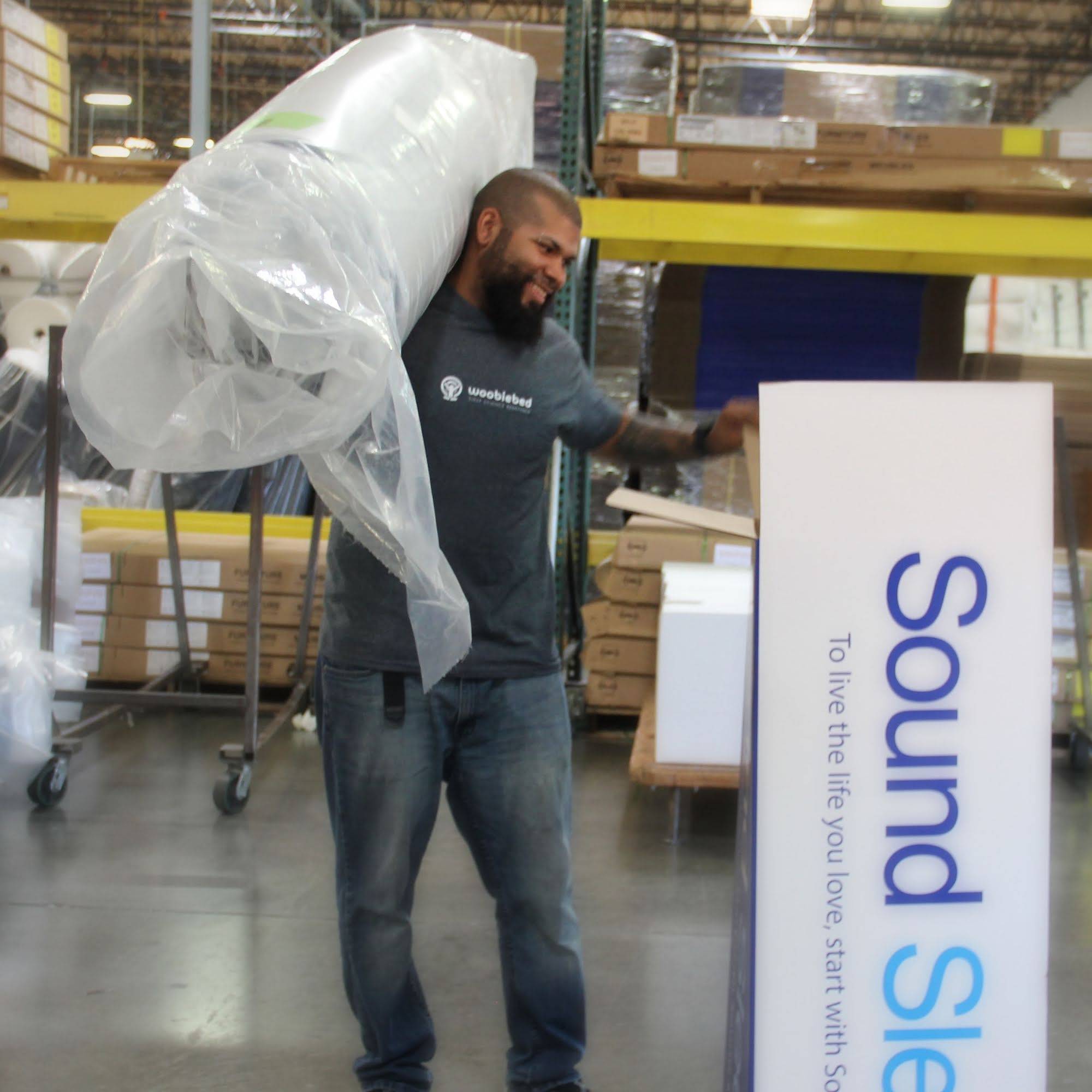 A man at the factory boxing a mattress by Ergo-Pedic.