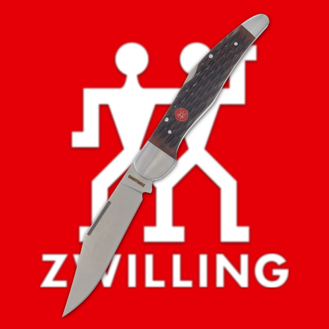 Knife with a black handle on a red Zwilling logo background.