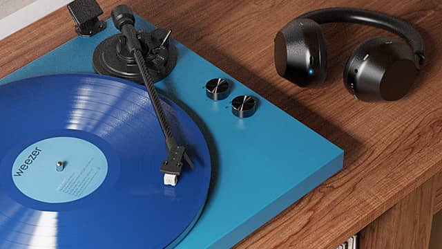 Blue vinyl record on a turquoise turntable with headphones beside it.