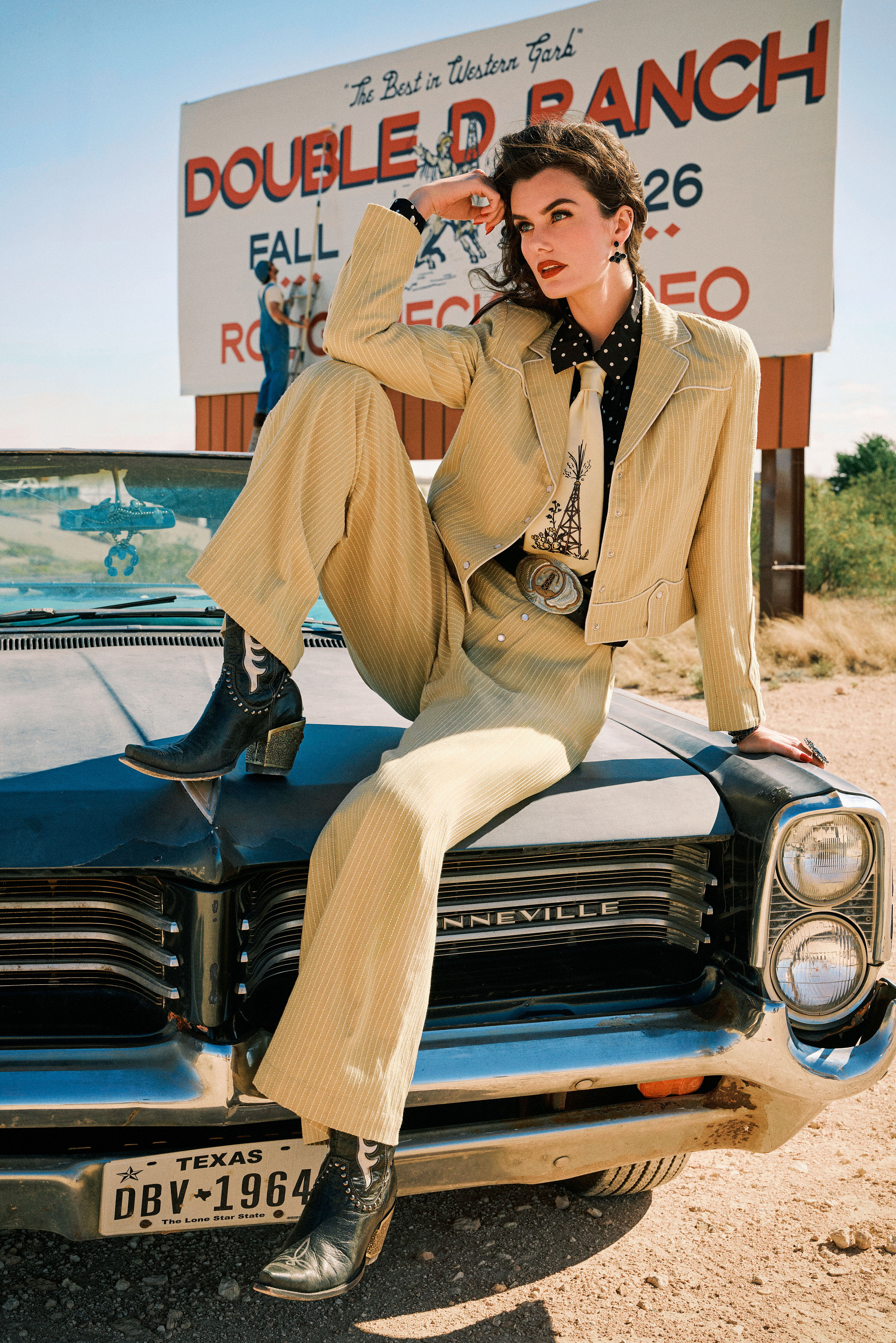 Kaylin wearing the Texas Timexes Jacket and Pant set with the Spew Blouse, Oil Camp Tie, Cattleman Boots, and Double D Ranch jewelry and accessories.