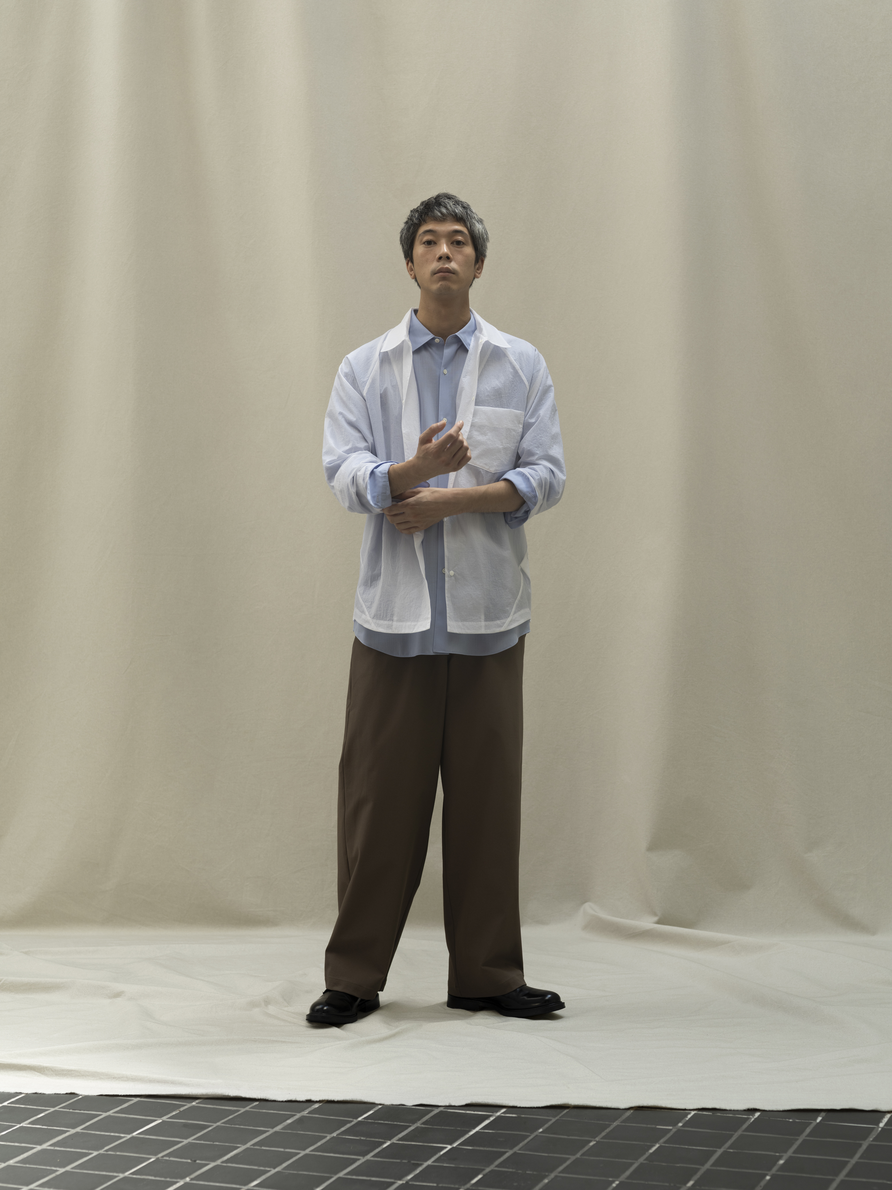 Person standing in front of a neutral background, wearing casual clothing.