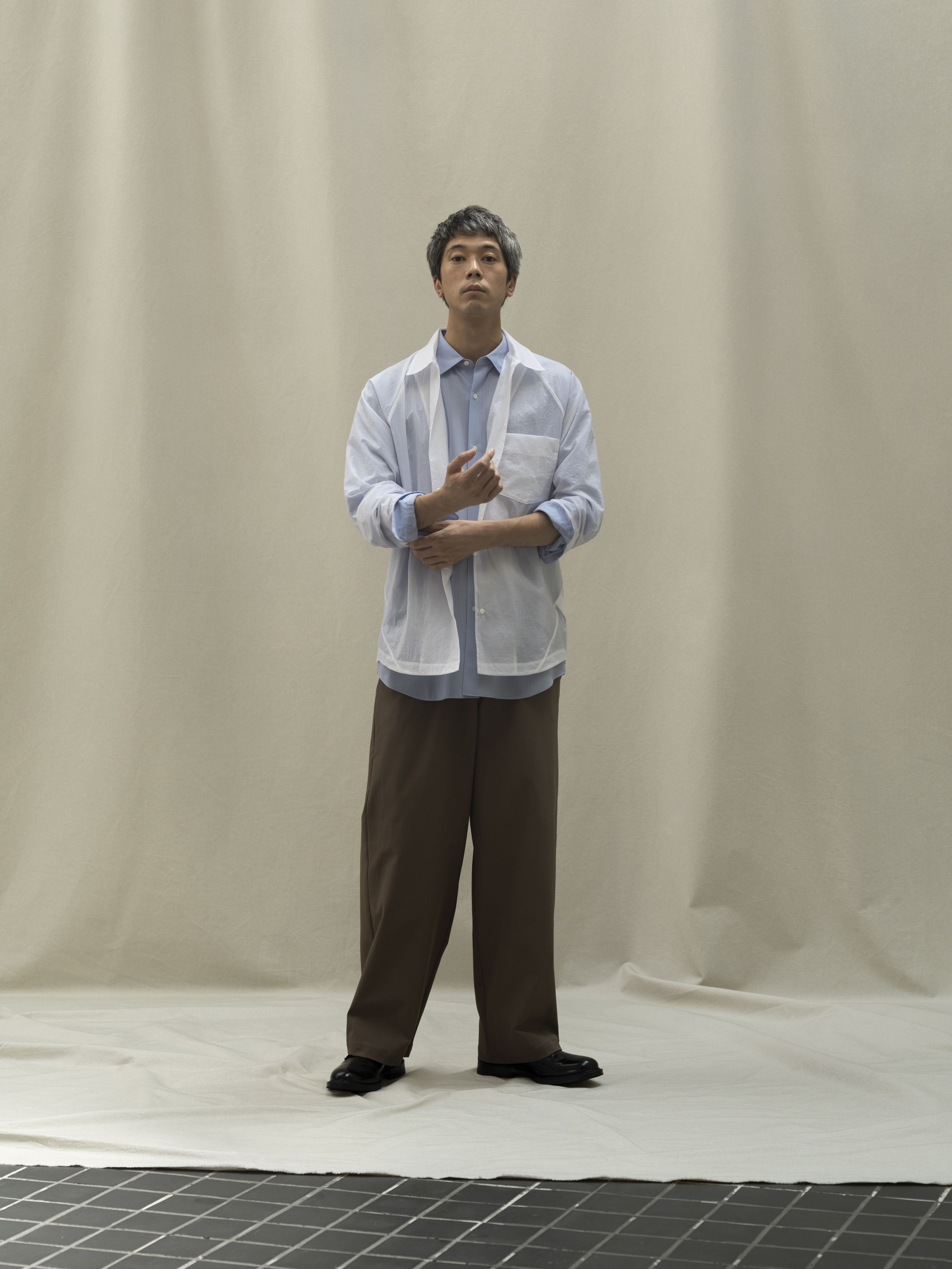Person standing in front of a neutral background, wearing casual clothing.