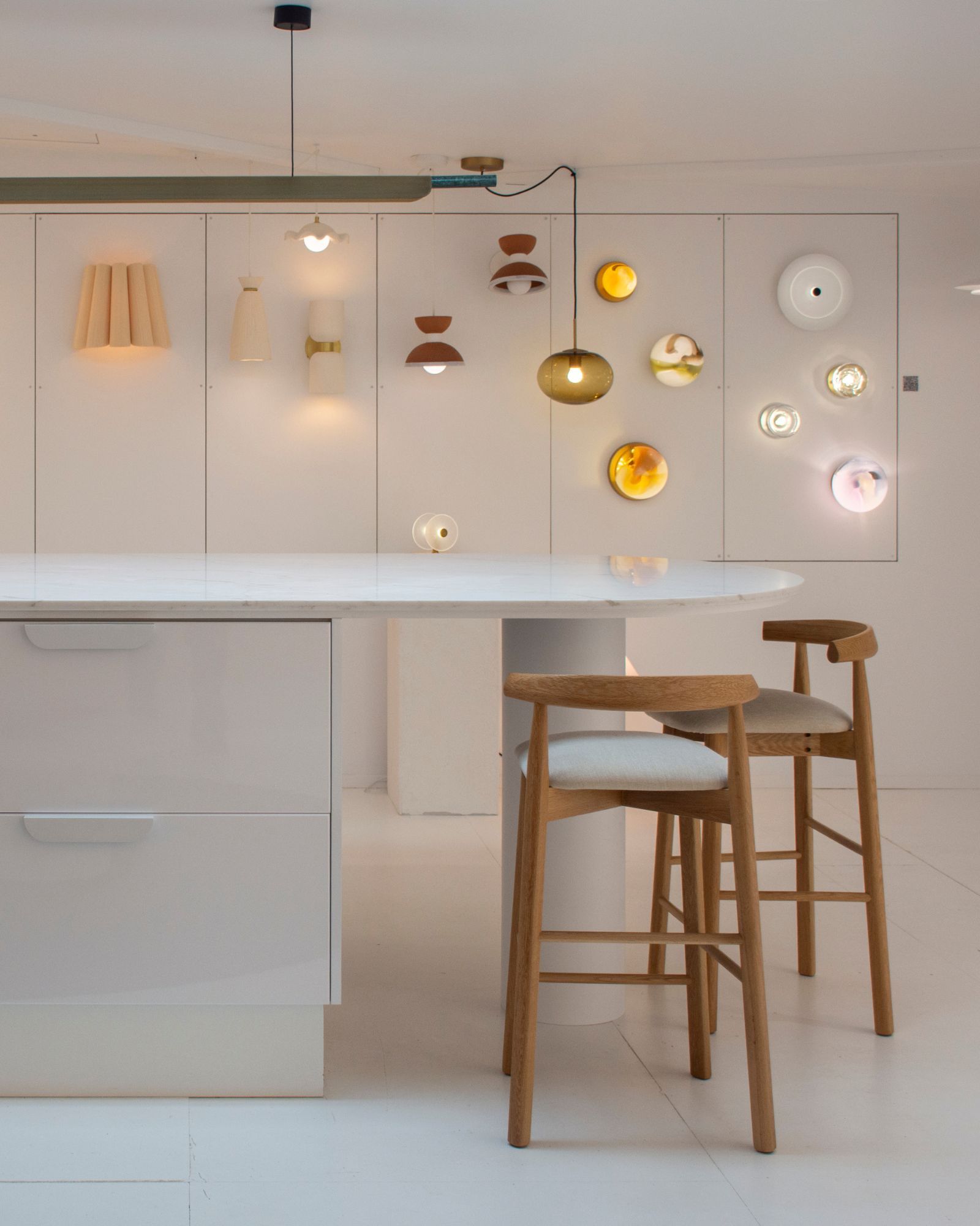 Modern bench with bar stools and decorative wall lights.
