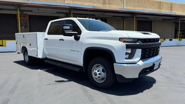 Front three-quarter view of George's white 2022 Chevrolet Silverado 3500 HD service truck parked outside a warehouse, install photo 1