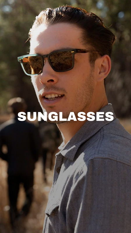 A person wearing sunglasses with others in the background.