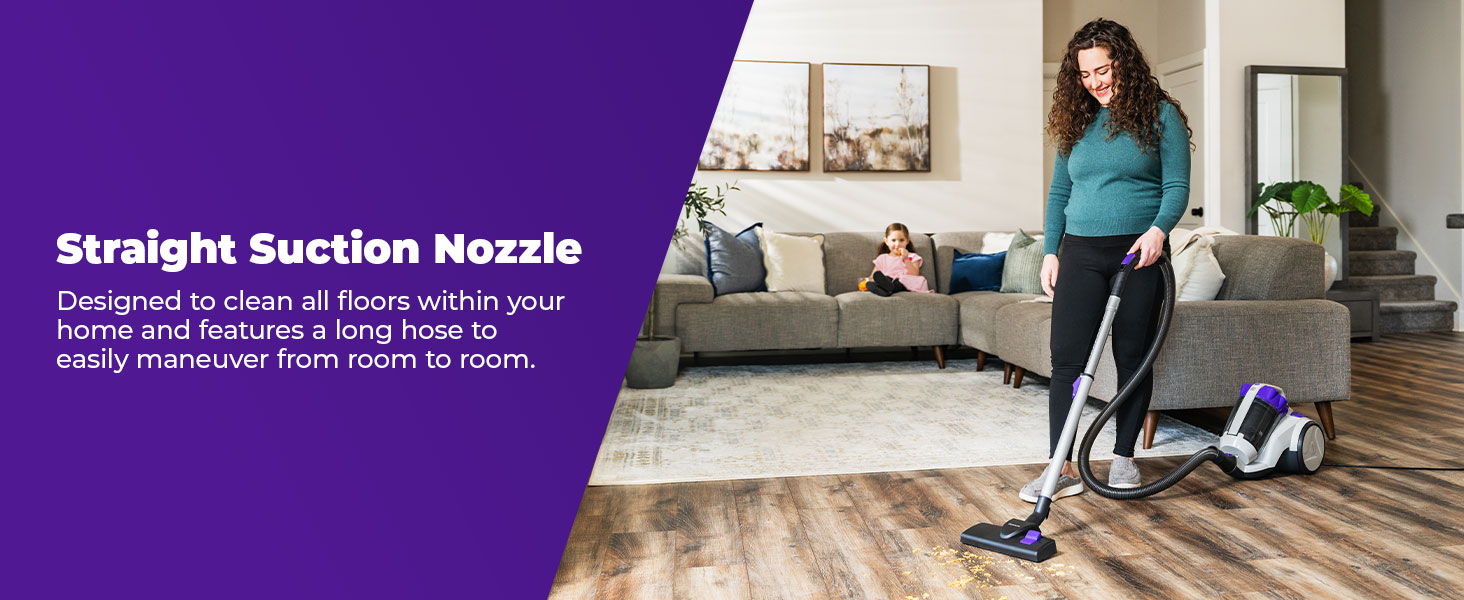 Woman using a vacuum cleaner on hardwood floors in a living room setting.