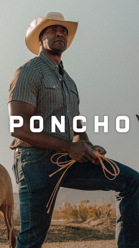 A man in a cowboy hat holding a rope outdoors.