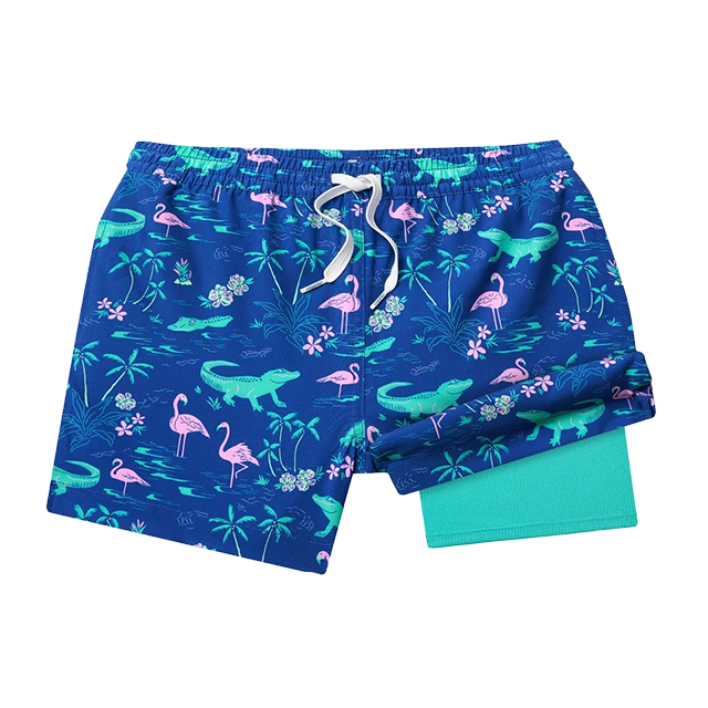 Colorful swim trunks with dinosaur and flamingo patterns on a blue background.