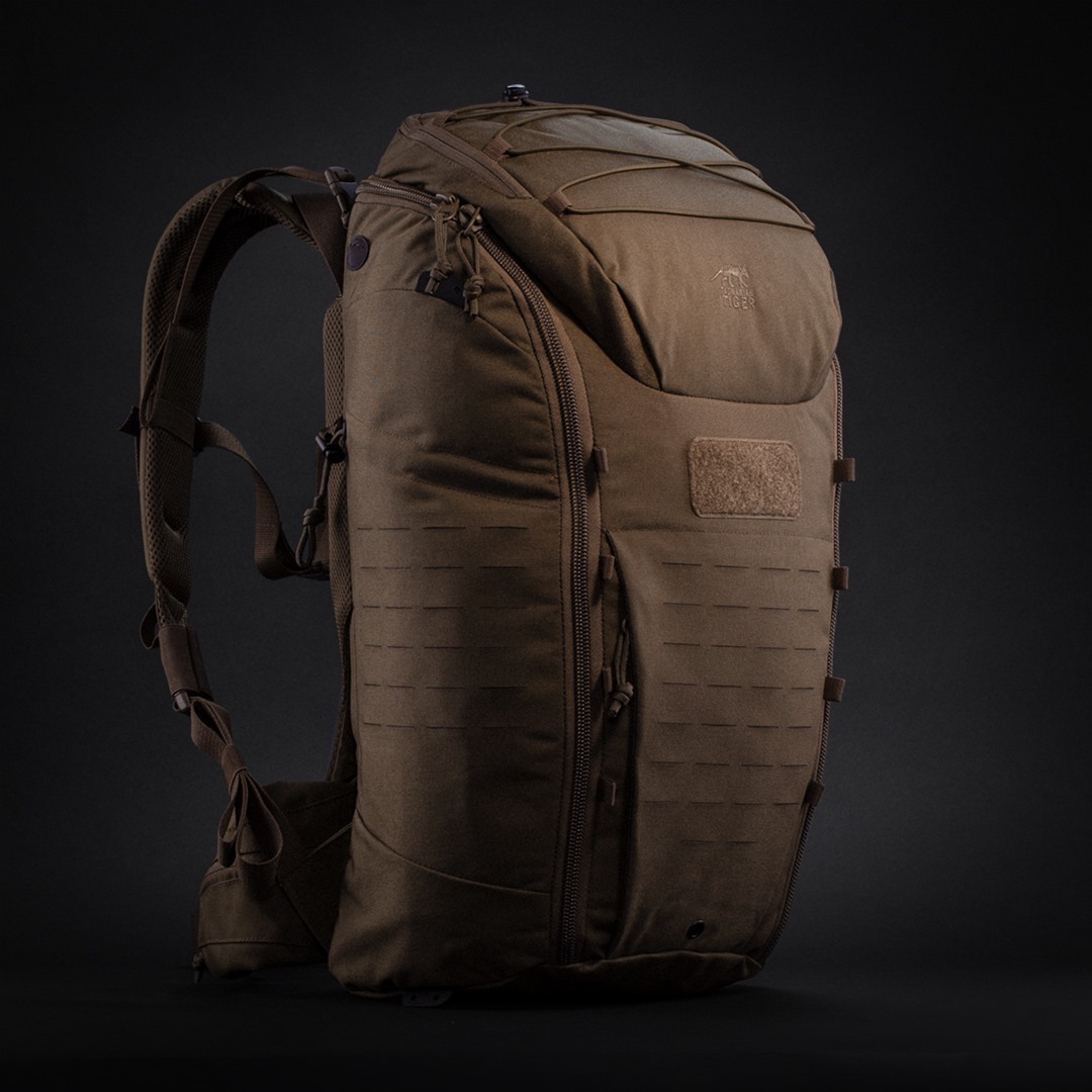 Brown tactical backpack against a dark background.