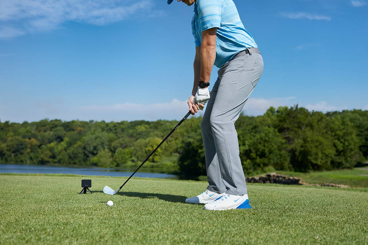 A golfer on the golf course with the Garmin Approach R10 launch monitor