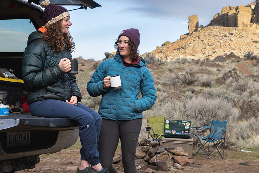 Two women camping with coffee mugs