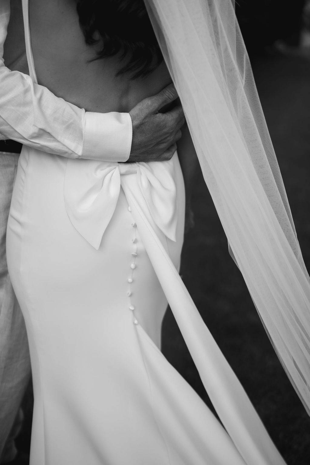 Close-up of the groom's hand resting on the bride's waist