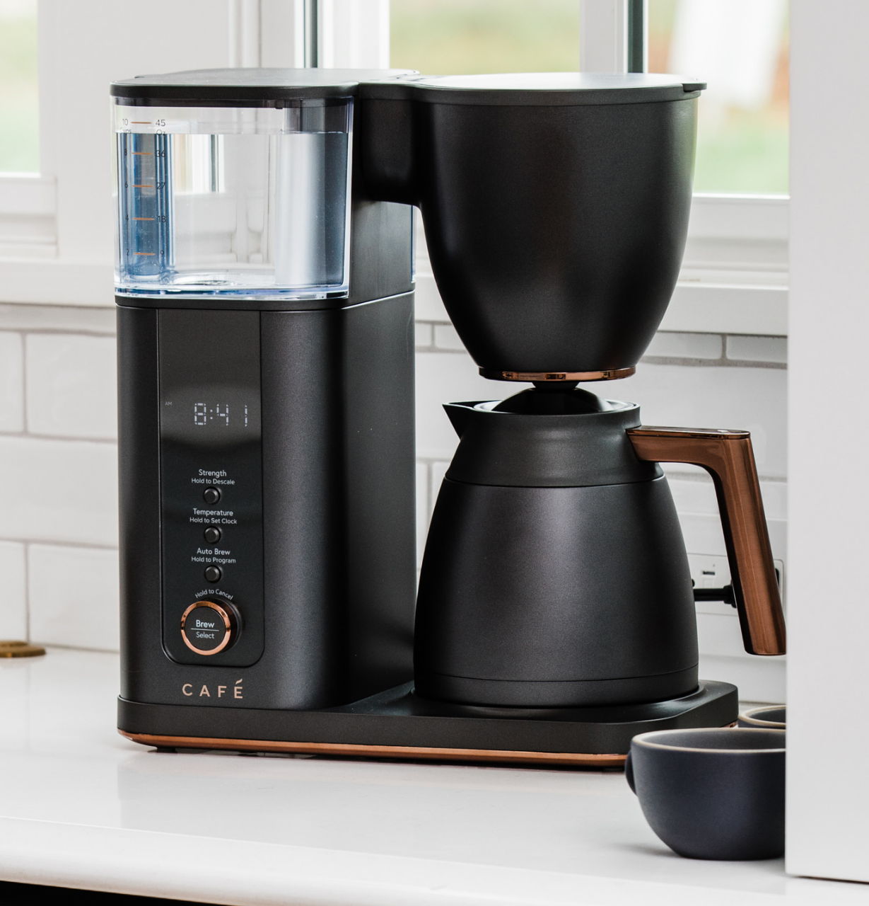 A matte black coffee maker on a kitchen countertop.