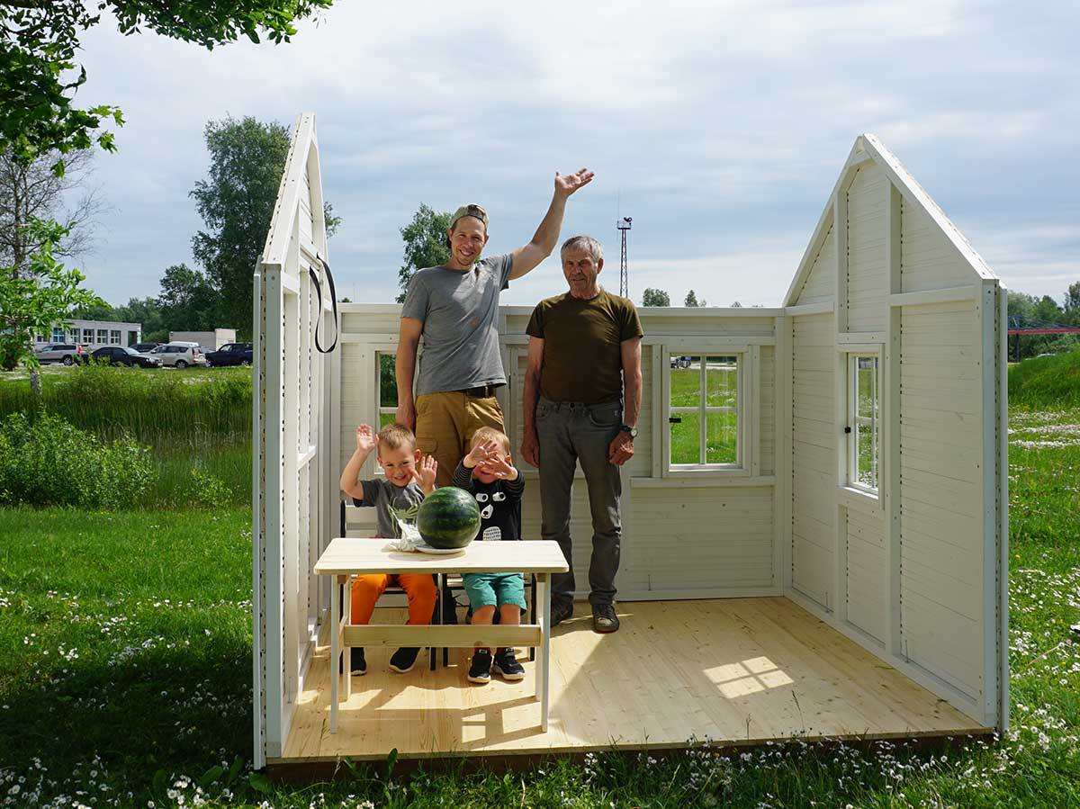 Boys with their dad and granddad installing a White and Black Kids Playhouse Arctic Nario by WholeWoodPlayhouses