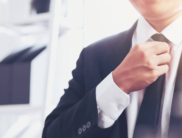 Man adjusting a black necktie