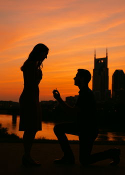 Silhouette of a man proposing at sunset with Nashville skyline in the background