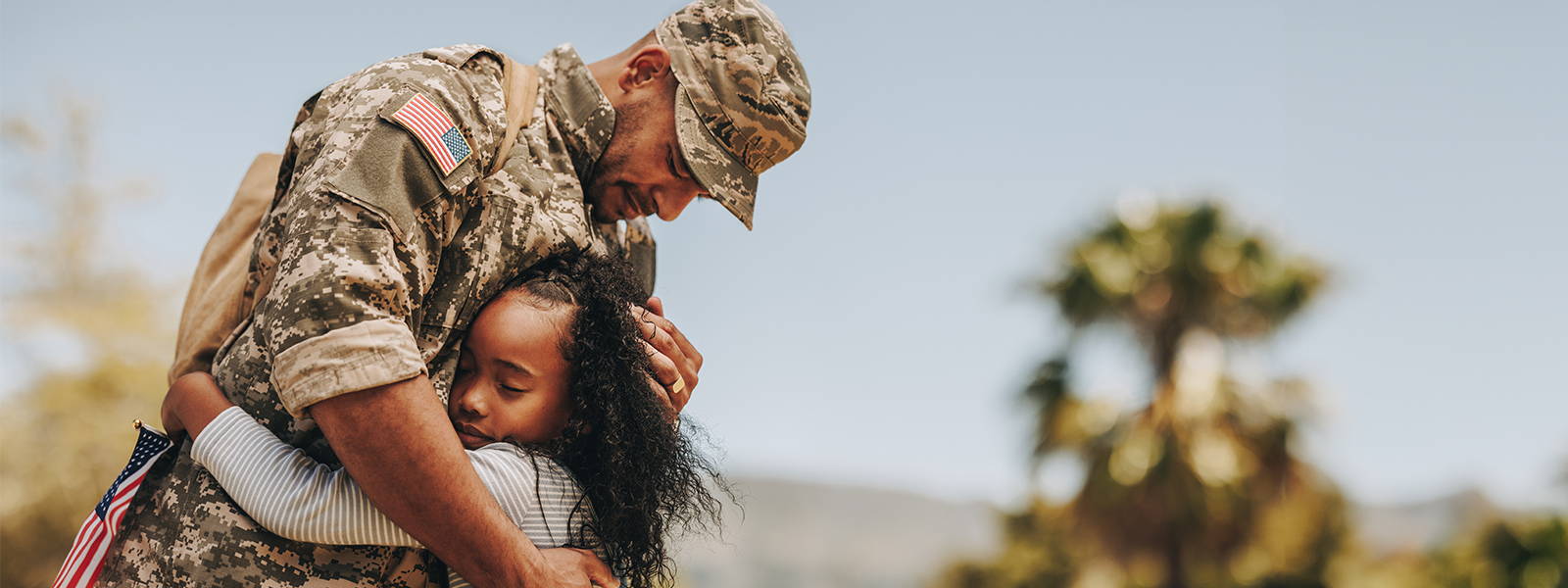 military dad hugging his daughter
