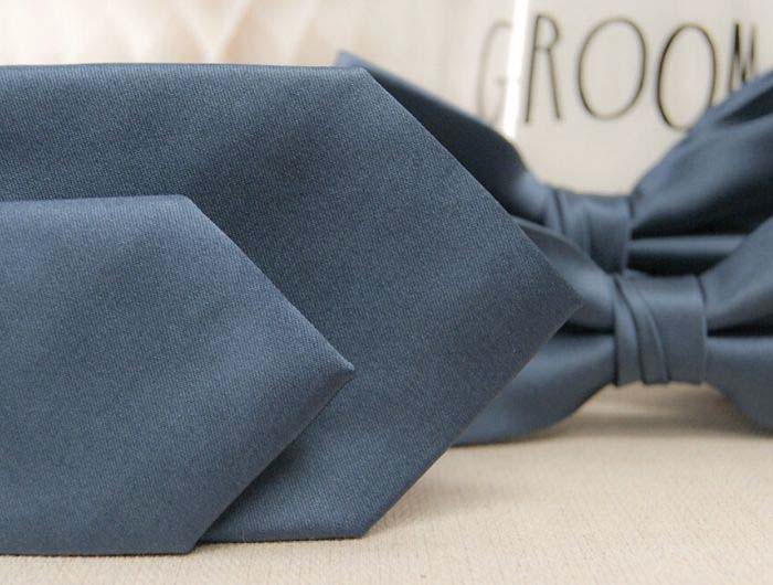 Dusty blue ties and bow ties with a glass that says groom