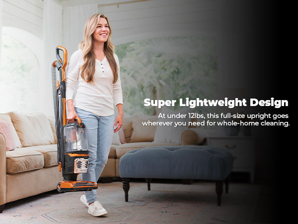 A woman using a vacuum cleaner in a modern living room setting.