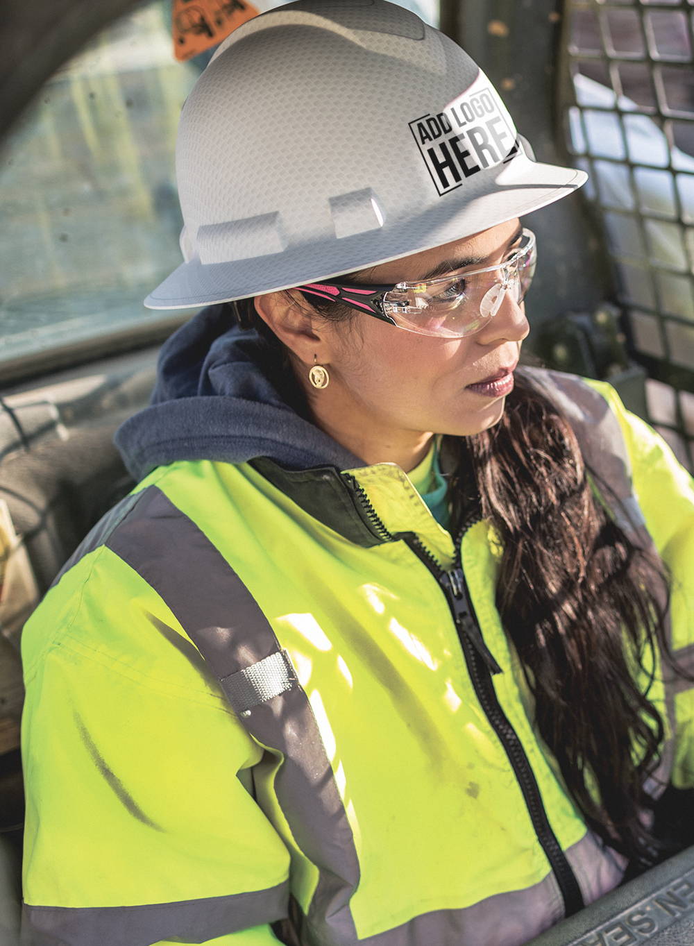 Woman construction worker wearing hi-vis jacket, safety glasses and full brim hard hat with company logo custom printed on the front.