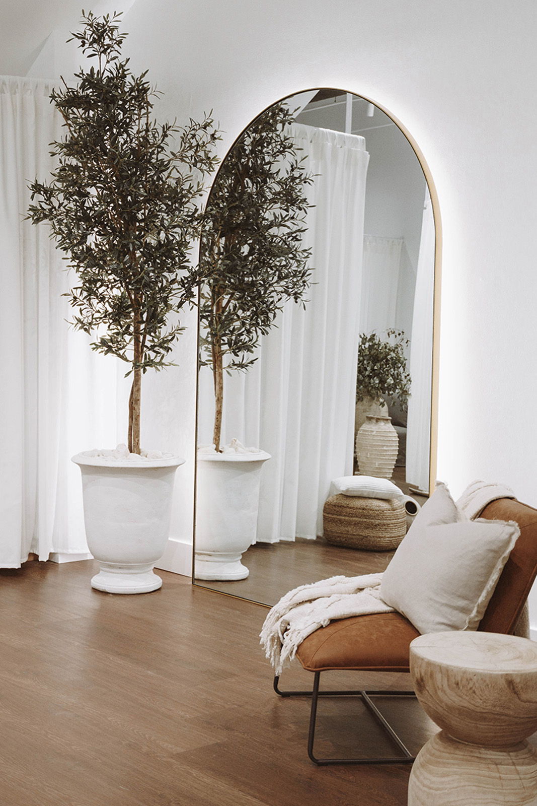 Cozy interior with plants, mirror, sofa, and decorative elements.