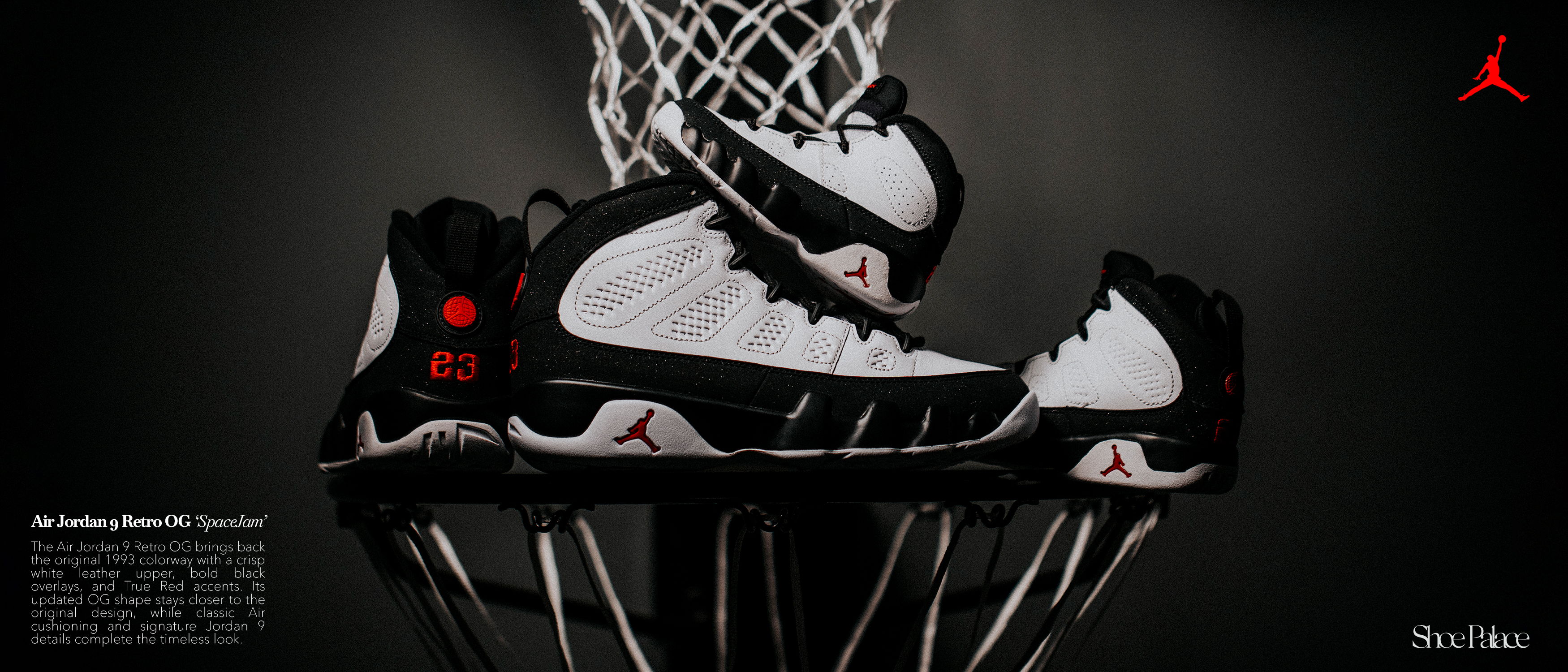 A pair of black and white basketball shoes in a basketball net.
