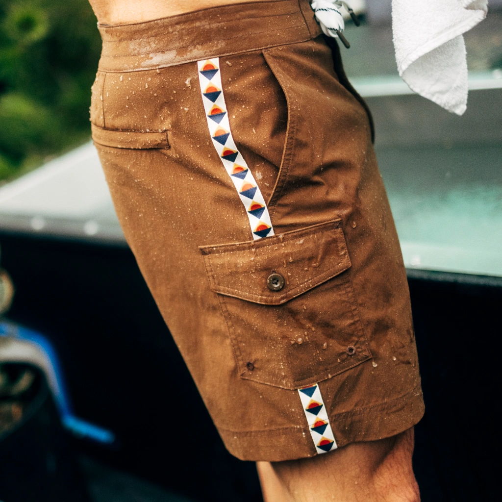Brown shorts with decorative side stripes and pockets.