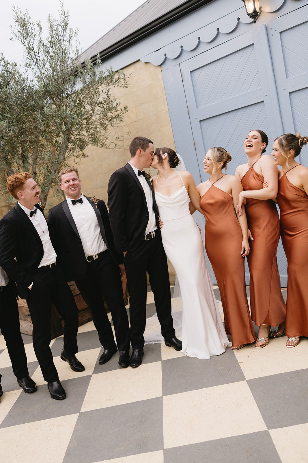 Group of people in formal attire, posing together in a stylish setting.