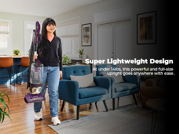 A person carrying a lightweight vacuum in a modern living room.