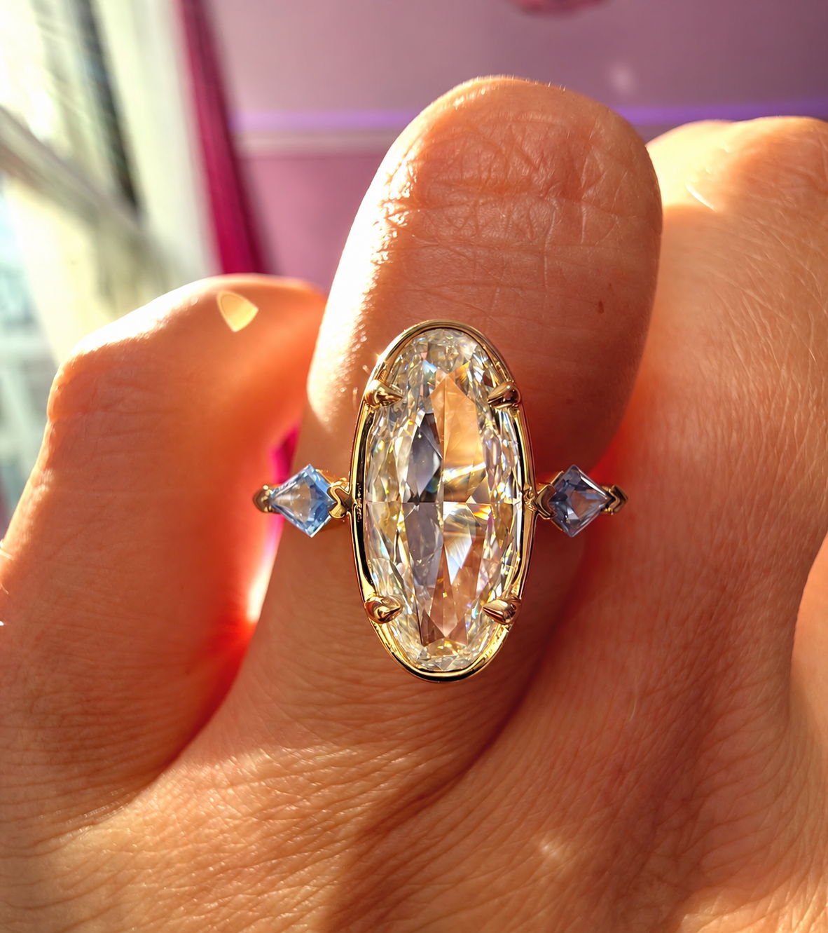 Moval cut diamond ring with blue sapphire side stones