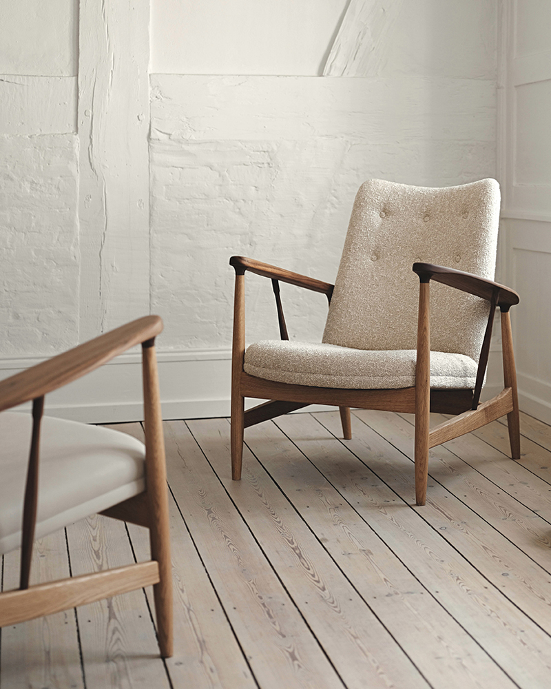 Two stylish Kettelhut Lounge chairs by House of Finn Juhl in a minimalist interior with wooden floors and white walls.