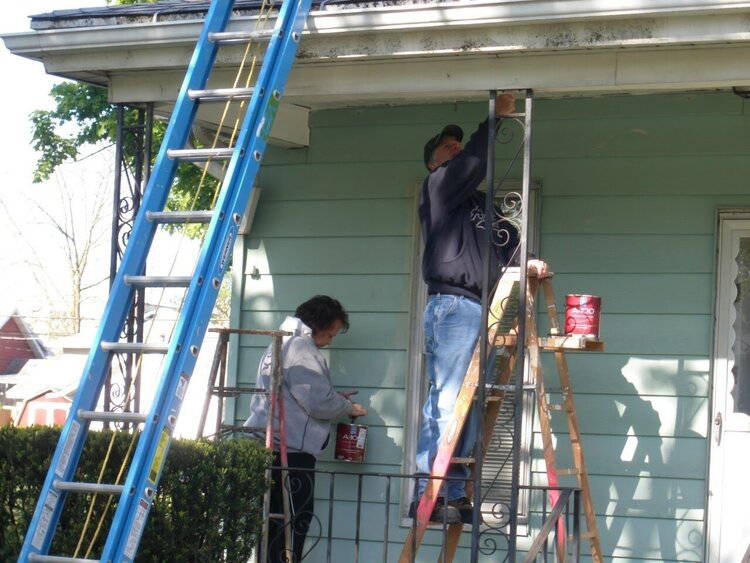 People painting the outside of a house