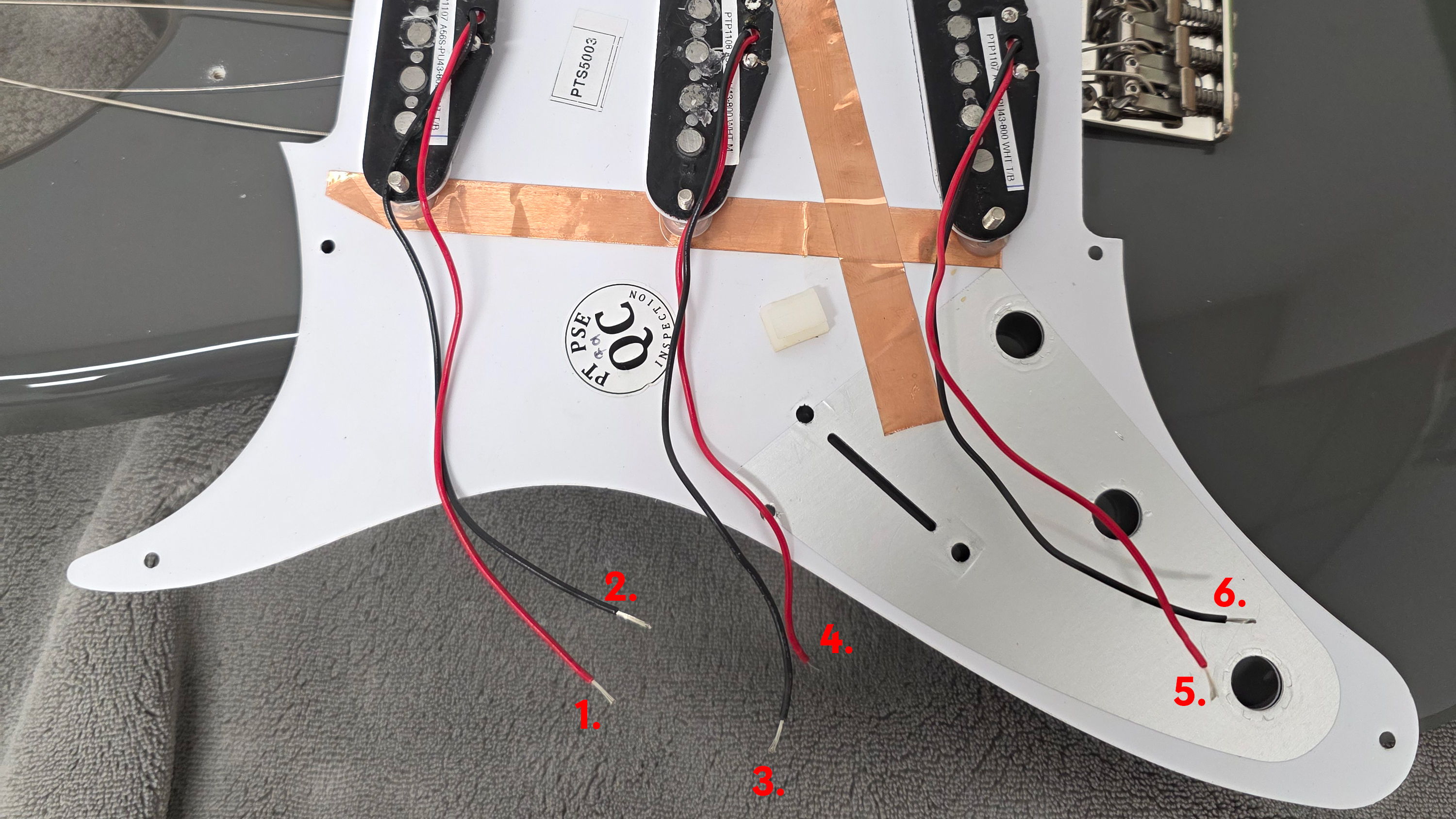Wiring and components of an electric guitar's pickguard.